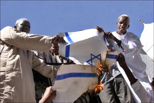 dos hombres quemando la bandera de israel